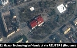 Imagine din satelit a Teatrului dramatic din Mariupol înainte de bombardarea sa de către armata rusă, cu cuvântul „copii” scris în limba rusă cu litere mari albe pe pevajul din în fața și din spatele teatrului, 14 martie 2022 (Maxar Technologies/via REUTERS)