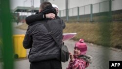 A man greets his family after crossing the Ukrainian-Polish border at Medyka in southeastern Poland on March 16.