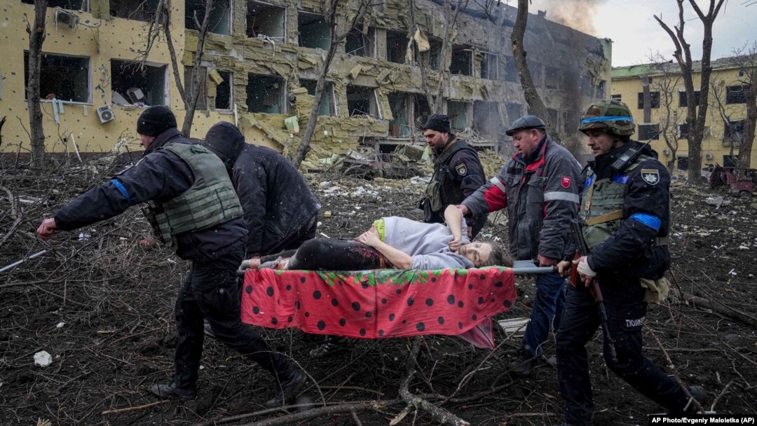 Ukrainian emergency employees and volunteers carry an injured pregnant woman from a maternity hospital after it was shelled on March 9. The woman and her unborn child later died.
