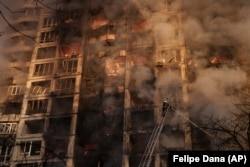 Firefighters tackle blazes in an apartment building after it was hit by shelling in Kyiv on March 15.