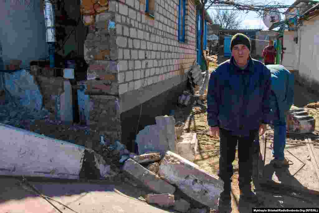 Житель Вознесенска Юрий Орленко стоит возле своего дома, поврежденного российским БТР. На нем военные пытались заехать во двор мужчины