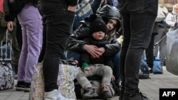 Майка прегръща сина си на гара в Полша на 18 март. И двамата са бежанци от Украйна. 