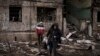 Civilii din Kiev își scot bunurile dintr-o clădire distrusă după ce aceasta a fost bombardată de artileria rusă, luni, 14 martie 2022. (AP Photo/Felipe Dana)