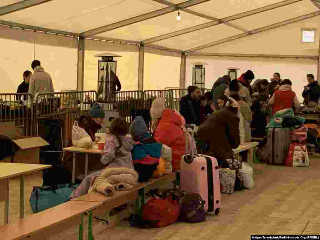 У цьому місці волонтери роздають біженцям гарячий чай, каву, гарячу їжу і солодощі дітям &ndash; це гуманітарна допомога, яка надходить із Польщі і з України