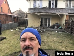 Роман Власенко на фоне своего обстрелянного российскими военными дома в Ворзеле