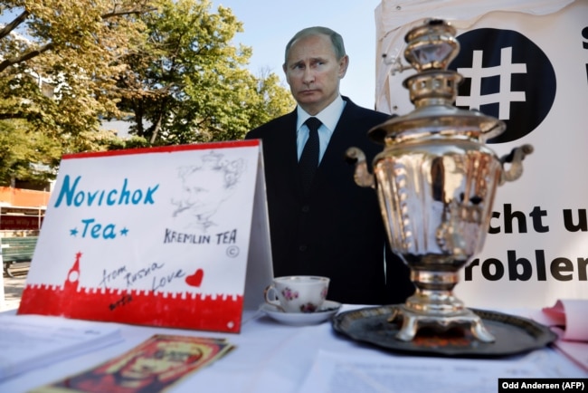 Изображение Владимира Путина и самовар с "чаем "Новичок" во время акции протеста у посольства России в Германии. Берлин, 23 сентября 2020 года