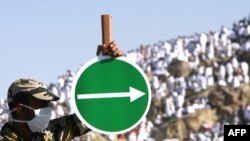Полиция қызметкері қажылыққа келгендерге Арафат тауына бағыт көрсетіп тұр. Мекке, Сауд Арабиясы, 7 желтоқсан 2008 ж.