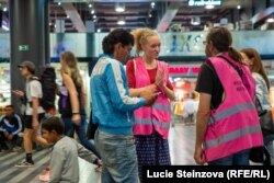 Vendula Fortova of the NGO Iniciativa Hlavak assists Robert Horvat (center), a Ukrainian refugee, and Prague's railway station.