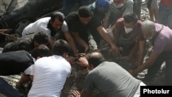 Armenia - Citizens help rescue workers remove the rubble at the site of a major explosion and fire in the Surmalu shopping center in Yerevan. August 14, 2022.