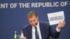 Presidenti i Serbisë, Aleksandar Vuçiq, duke mbajtur në duar një letër me targa KS. Këto targa, Serbia ka propozuar që të përdoren nga serbët në Kosovë. Por, Qeveria e Kosovës ka thënë se nuk mund të pranojë targa që kanë status neutral ndaj shtetësisë së Kosovës.
