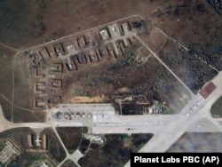 На этом спутниковом снимке, предоставленном Planet Labs PBC, виден уничтоженный российский самолет на авиабазе Саки после взрыва во вторник, 9 августа 2022 года.