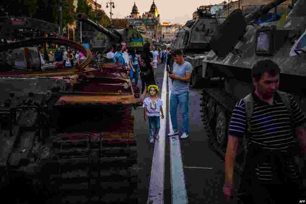 People walk among destroyed Russian military equipment on display in Kyiv on August 23.&nbsp;