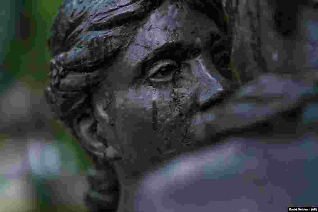 Raindrops roll down the face of a statue of a couple embracing in the city center of Druzhkivka, where many residents have evacuated, in Ukraine&#39;s eastern Donetsk region.