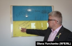 Посол України в Королівстві Швеція Андрій Плахотнюк демонструє прапор 503-го окремого батальйону морської піхоти