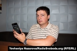 Адвокат Дмитро Гладкий показує програму eyeWitness to Atrocities на своєму мобільному