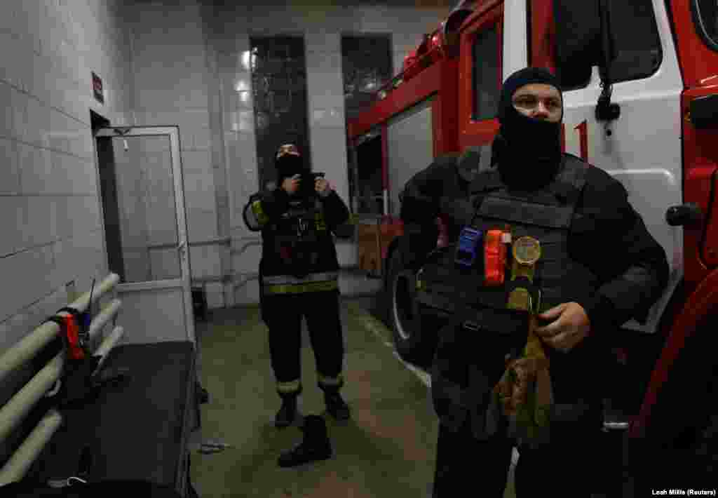 Олександр та його колега-пожежник швидко одягли своє спорядження, в яке тепер входять також бронежилети та джгути, перш ніж виїхати на нічний виклик у Харкові, 1 липня, 2022 рік &nbsp;