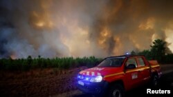 Tűzoltók dolgoznak egy erdőtűz megfékezésén Belin-Béliet-ben, Franciaországban 2022. augusztus 10-én