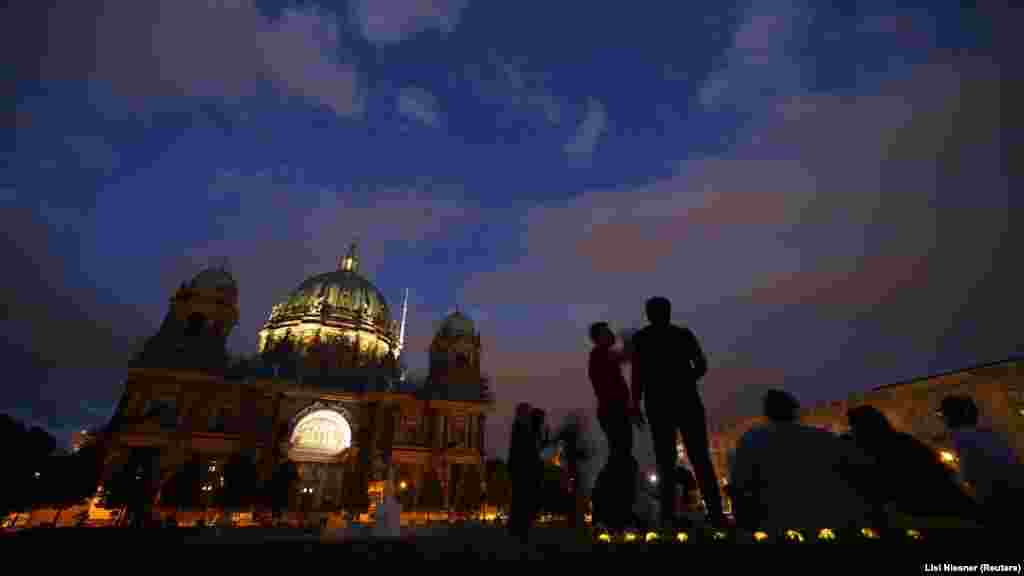 I u Berlinu povijesna mjesta stoje uglavnom neosvijetljena nakon zalaska sunca. Ljudi uživaju u ljetnim večerima pokraj središnje berlinske katedrale.