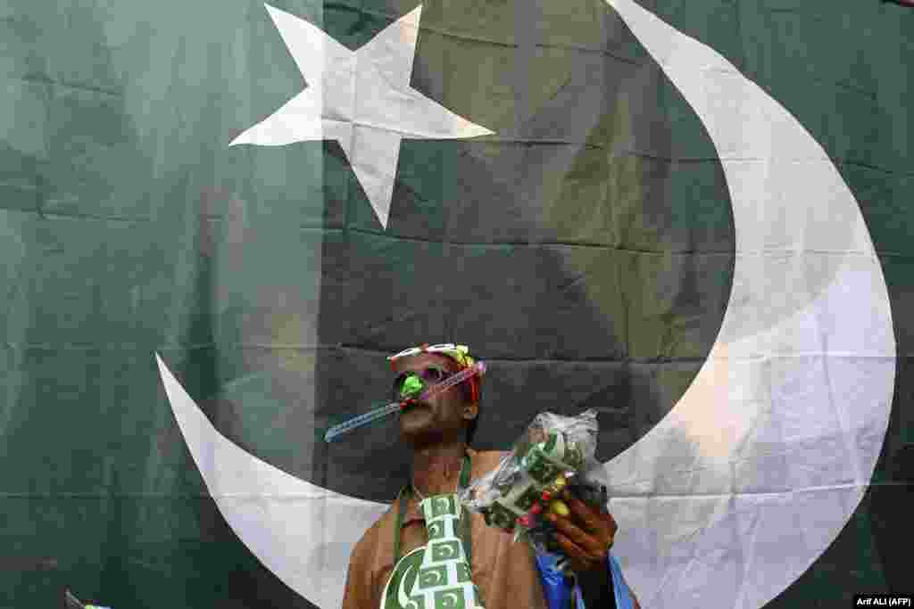 A vendor selling Pakistani national flags waits for customers along the roadside ahead of the 75th Independence Day celebrations in Lahore on August 10.