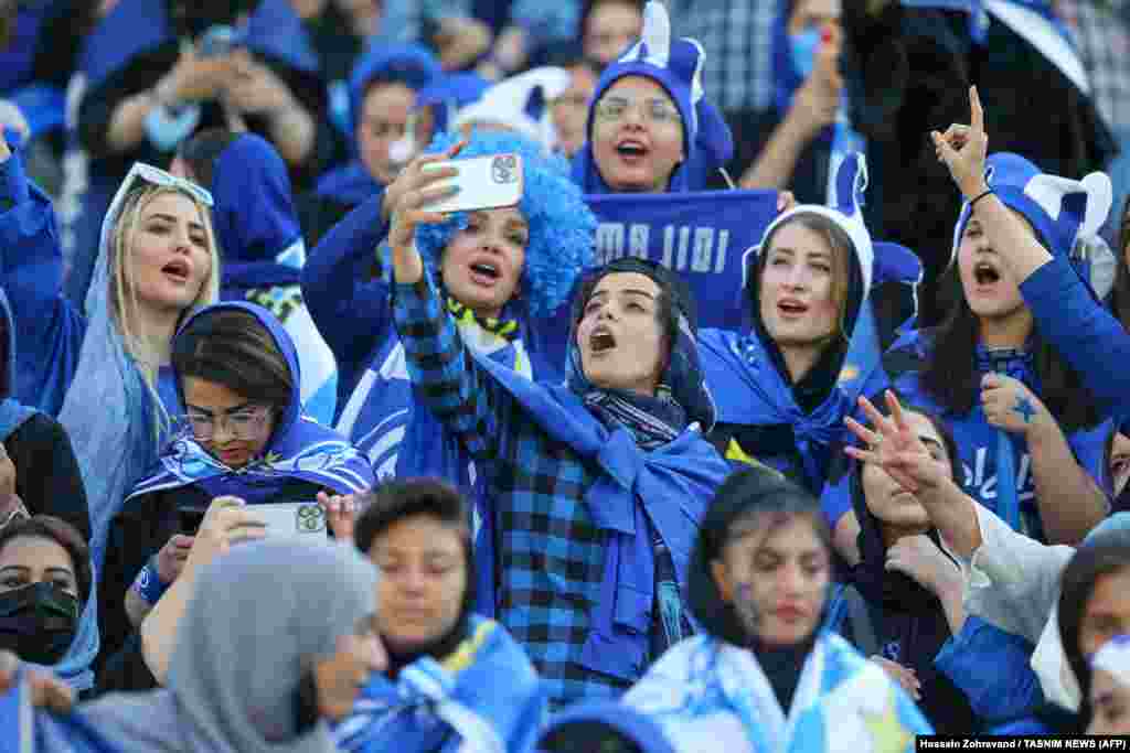 Navijačice fudbalskog kluba Esteghlal navijaju tokom utakmice između Esteghlala i Mesa Kermana na stadionu Azadi u Teheranu 25. augusta. Irankama je bilo dozvoljeno da prisustvuju utakmici nacionalnog fudbalskog prvenstva prvi put od Islamske revolucije 1979. godine, u sadašnjosti pozdravljen kao istorijski potez.