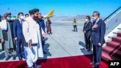 The Afghan Taliban's acting foreign minister Amir Khan Muttaqi (left) greets visiting Chinese diplomat Wang Yi (right) upon his arrival in Kabul last year. 