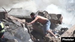 Мъж търси хора сред руините на съборения търцовски център, Ереван, 14 август.