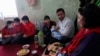 An Afghan refugee in Tajikistan sits with his family in their apartment in the Tajik town of Vakhdat in 2010.