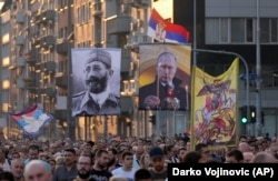 Protesters in Belgrade on August 28 march in opposition to planned LGBT celebrations while carrying Russian flags and a picture of Russian President Vladimir Putin (right) and controversial Serb World War II General Dragoljub Mihailovic