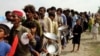 People affected by the recent flooding wait for food distributed by Pakistani soldiers in a flood-hit area in Rajanpur, Punjab Province, on August 27.