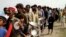 People affected by the recent flooding wait for food distributed by Pakistani soldiers in a flood-hit area in Rajanpur, Punjab Province, on August 27.
