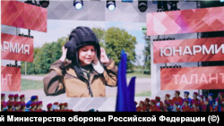 Льоша Павличенко, показан на голям екран по време на церемонията, в която става член на Юнармия.