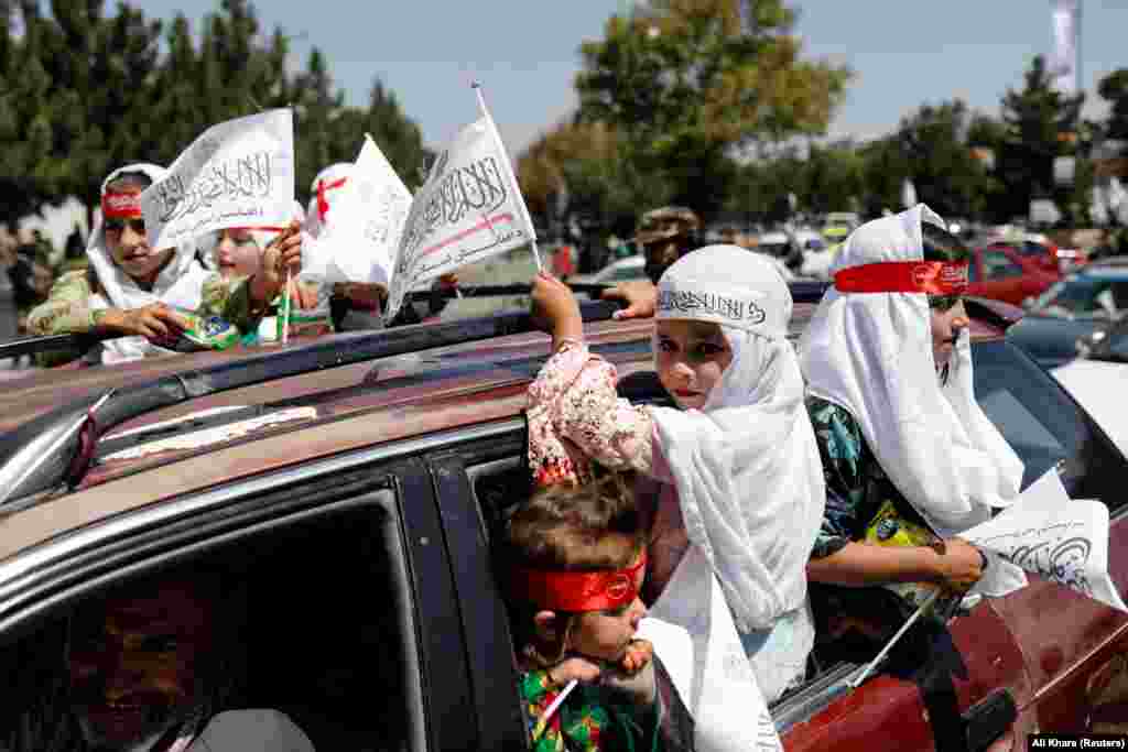 Girls on a street in Kabul take part in Taliban celebrations marking the first anniversary of the final withdrawal of U.S. troops from Afghanistan.&nbsp;