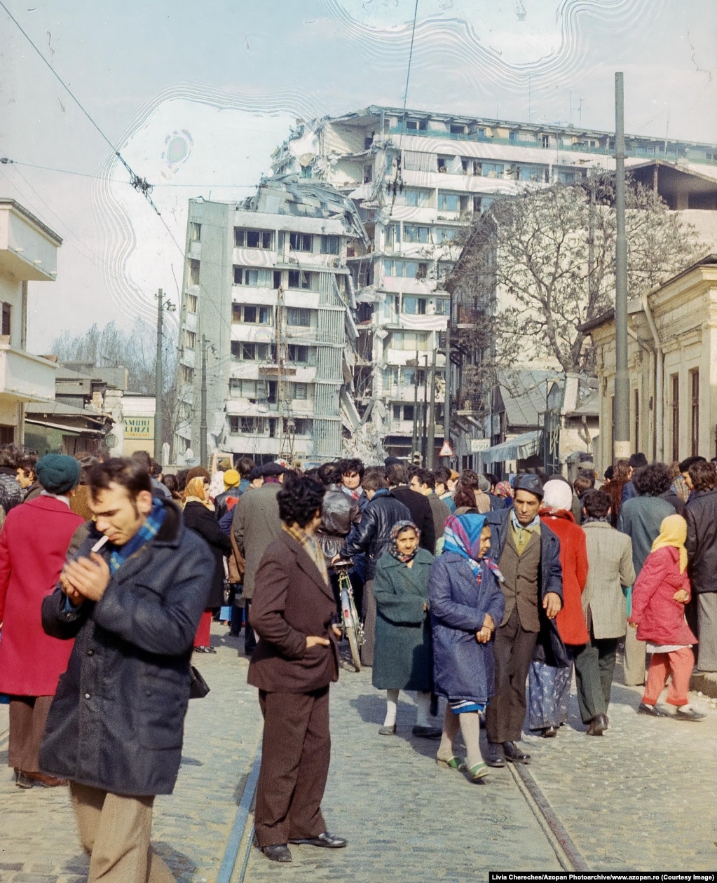 Turma njerëzish të grumbulluar afër një ndërtese banimi në qendër të Bukureshtit, e cila u dëmtua rëndë nga tërmeti.