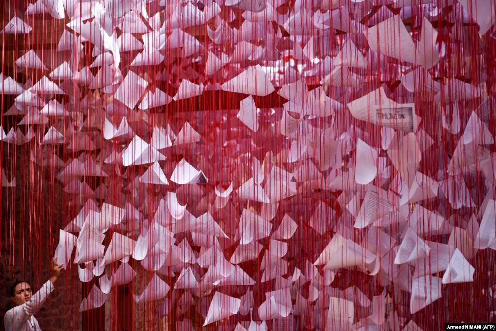 Një vizitor duke shikuar një vepër artistike instalacioni të quajtur "Tell Me Your Story" nga artisti japonez Chiharu Shiota në Prishtinë më 16 gusht në edicionin e 14-të të Bienales Nomade Evropiane të mbajtur në Kosovë.