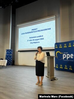 Șefa ISJ Cluj, Marinela Marc, la dezbaterea organizată pe plan local pe marginea legilor Educației, cu banner-ul PNL alături.