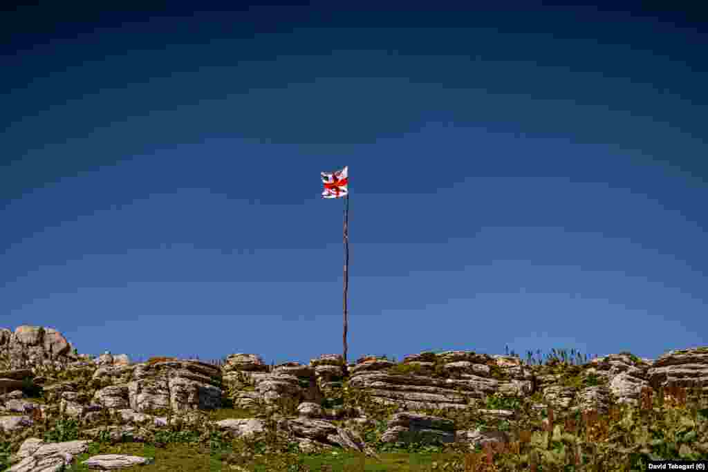 A Georgian flag in the mountains. The summer season for sulguni makers is relatively brief. By early autumn, the men will drive their herd back down to the lowlands to avoid the fierce mountain winter.