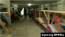 Деревянные кровати в бомбоубежище под школой, в котором живут пожилые люди. Село Лупарево, август 2022 года