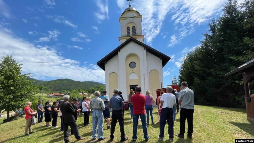 Edukacije vjerskih službenika podrazumijevaju rad s Centrima za socijalni rad, mentalno zdravlje i drugim organizacijama civilnog društva, te sigurnim kućama. (FOTO: Protojerej Neven Marinković s parohijanima ispred crkve u selu Kozica)
