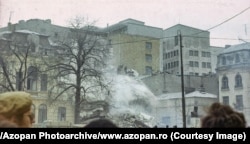 Muncitori îndepărtează dărâmăturile dintr-o clădire distrusă în centrul Bucureștiului.
