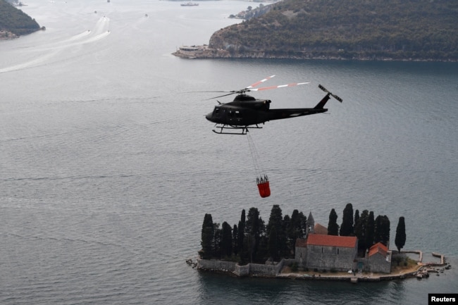 Vojni helikopter pomaže u gašenju šumskog požara u turističkom crnogorskom gradu Perastu u Bokokotorskom zalivu, 10. avgust 2022.