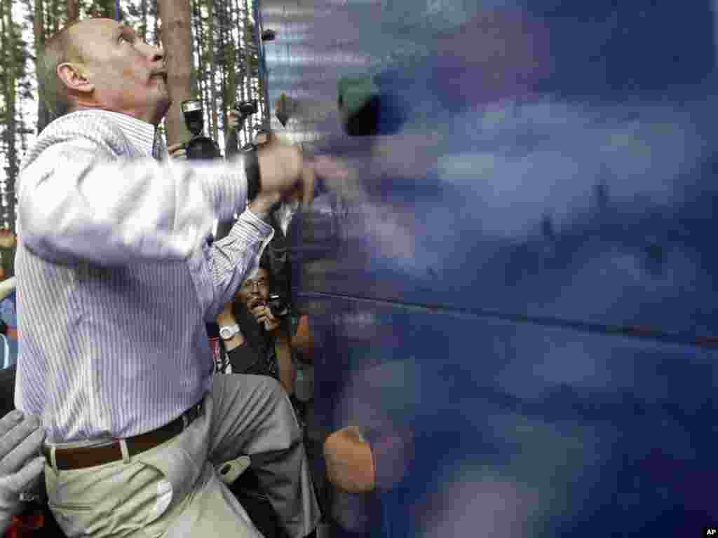 Russian Prime Minister Vladimir Putin scales a climbing wall during a visit to the Seliger youth educational forum near Lake Seliger, some 450 kilometers northwest of Moscow.Photo by Mikhail Metzel for AP