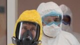Владимир Путин в желтом защитном костюме и главный врач московской больницы №40 в Коммунарке Денис Проценко