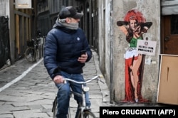 نقاشی دیواری یک هنرمند خیابانی بر اساس شعار «خدایا شکرت که سیلویو این‌جاست»، میلان، ژانویه ۲۰۲۲