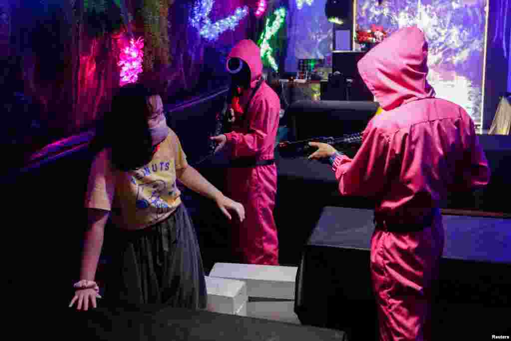 A customer plays &#39;Red Light, Green Light&#39; game from the Netflix show &#39;Squid Game&#39; at Strawberry Cafe in Jakarta, Indonesia, October 15, 2021