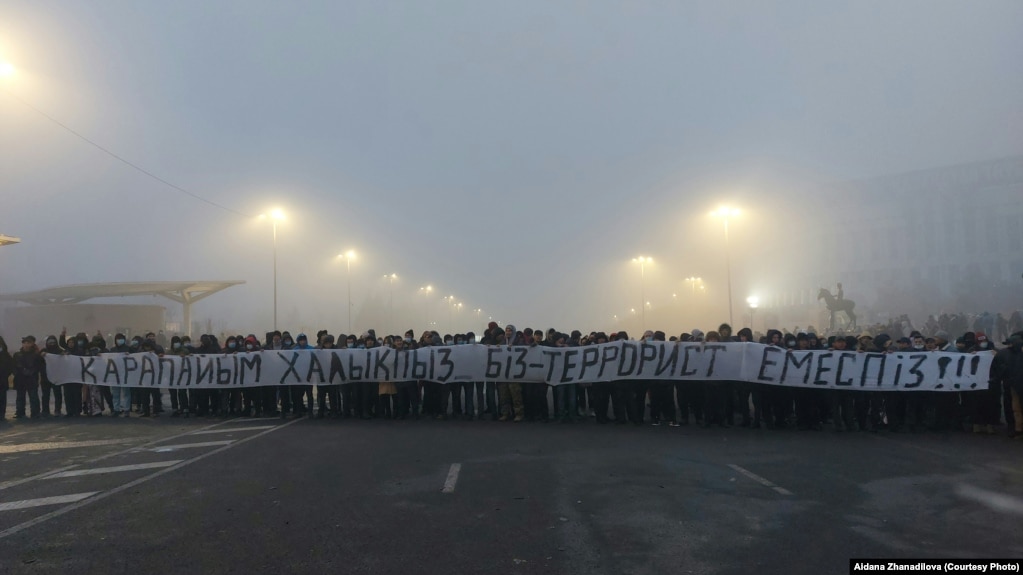 Протестующие на площади с огромной растяжкой «Мы простой народ. Мы — не террористы». Алматы, 6 января 2022 года