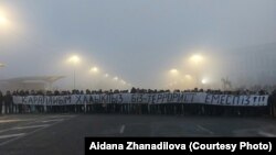 Республика алаңында "Қарапайым халықпыз. Біз – террорист емеспіз!!!" деген жазу ұстап тұрған адамдар. Куәгерлердің айтуынша, осы фото түсірілгеннен кейін біраз уақыт өткенде оларға жаппай оқ атылған. Алматы, 6 қаңтар, 2022 жыл.