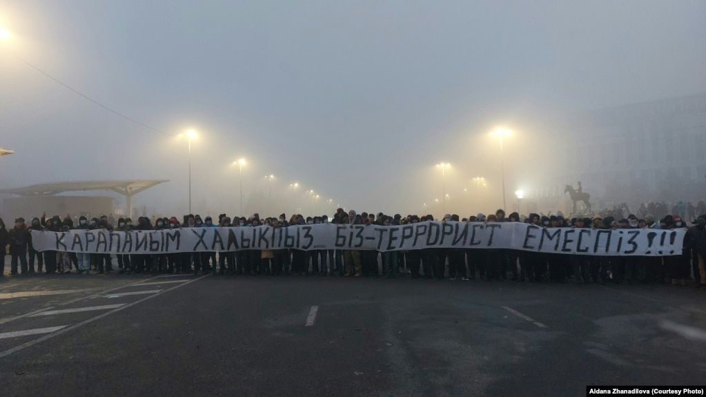 Протестующие на площади с огромной растяжкой «Мы простой народ. Мы — не террористы». Алматы, 6 января 2022 года