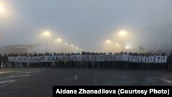 Протестующие на площади с огромной растяжкой «Мы простой народ. Мы — не террористы». Алматы, 6 января 2022 года