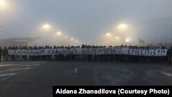 Республика алаңында "Қарапайым халықпыз. Біз — террорист емеспіз!" деген жазу ұстап тұрған адамдар. Алматы, 6 қаңтар, 2022 жыл