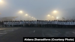 Протестующие на площади с огромной растяжкой «Мы простой народ. Мы — не террористы». Алматы, 6 января 2022 года